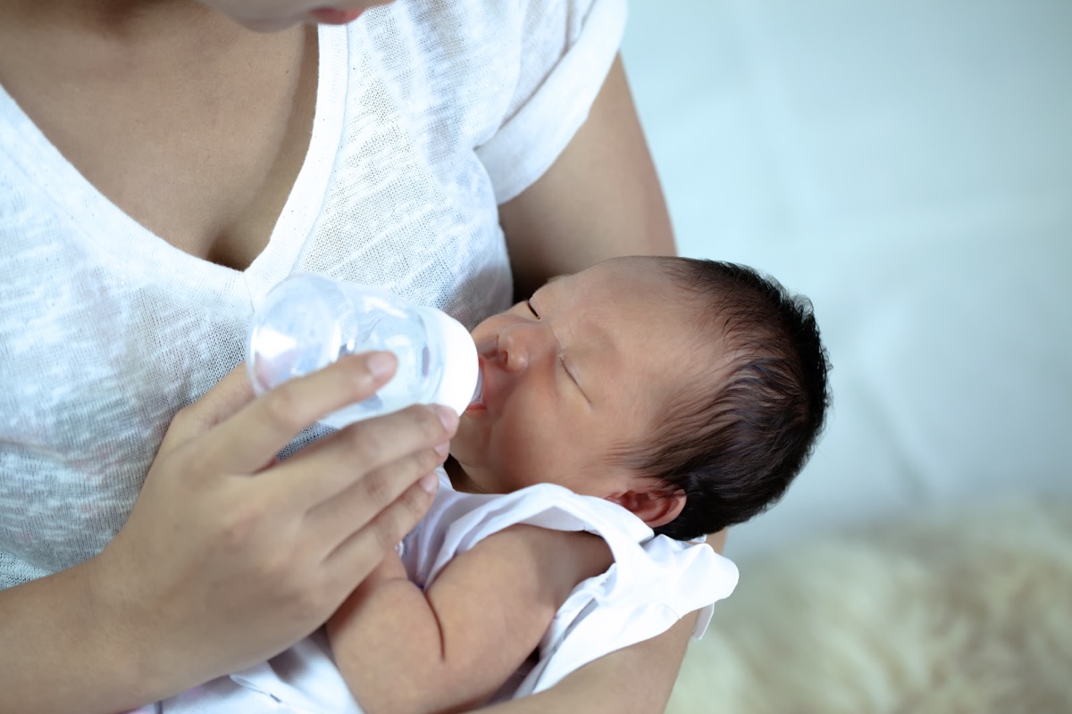 mother feeds the baby bottle