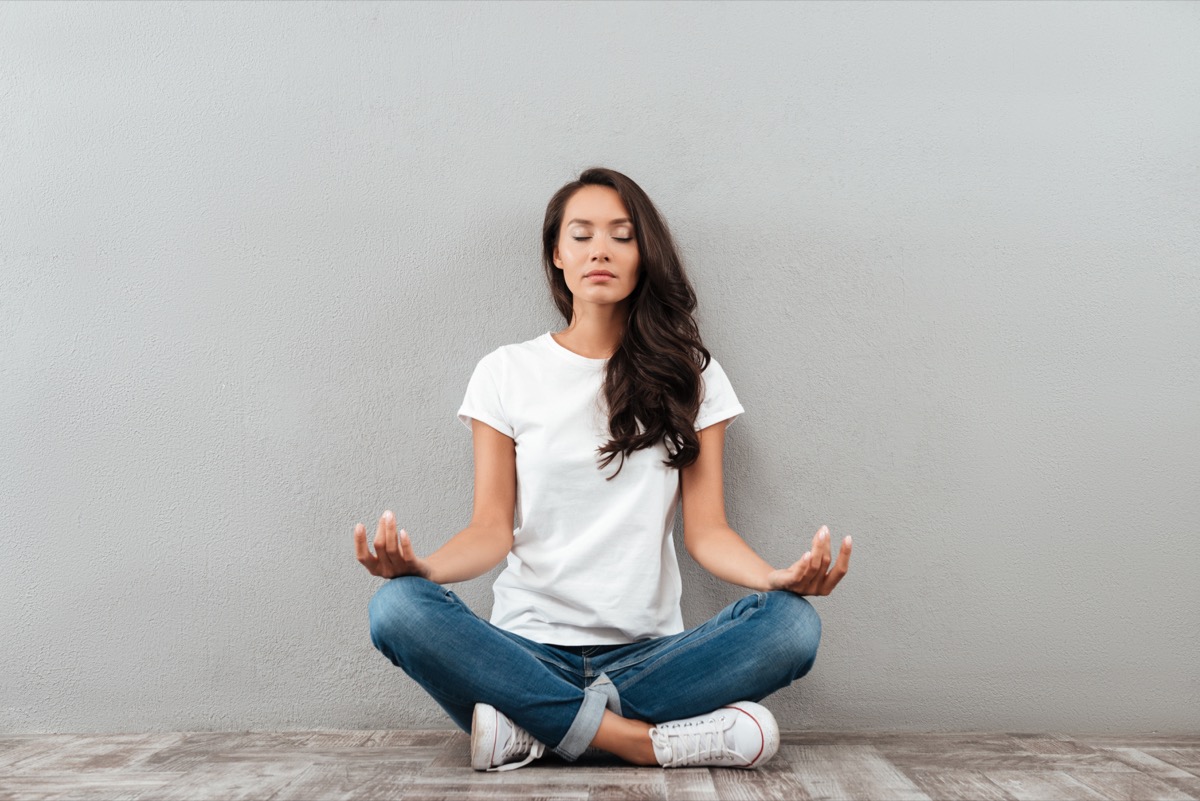 woman sitting in yoga position and meditating