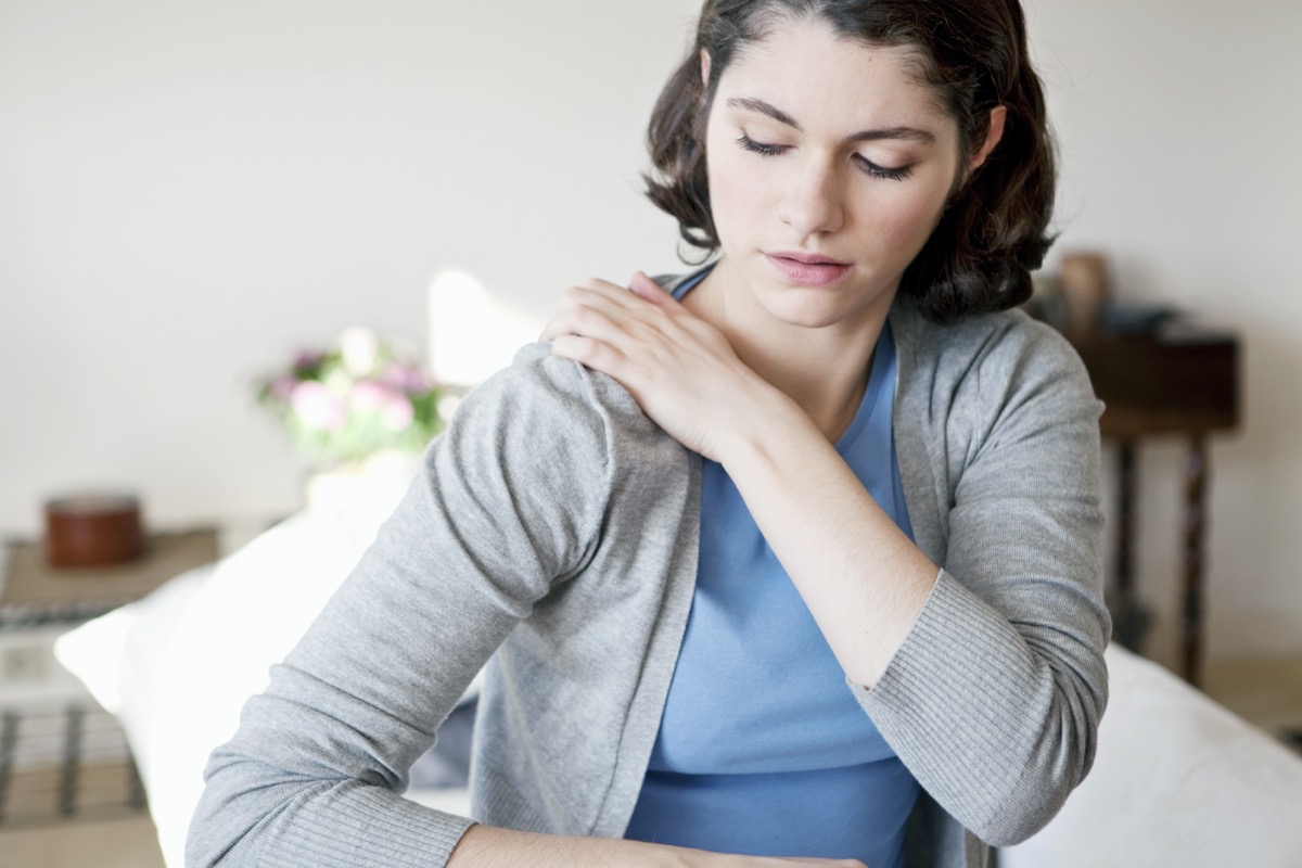 Woman touching her shoulder