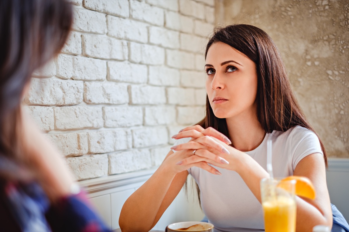 Girl with thinking expression trying to remember something at the cafe