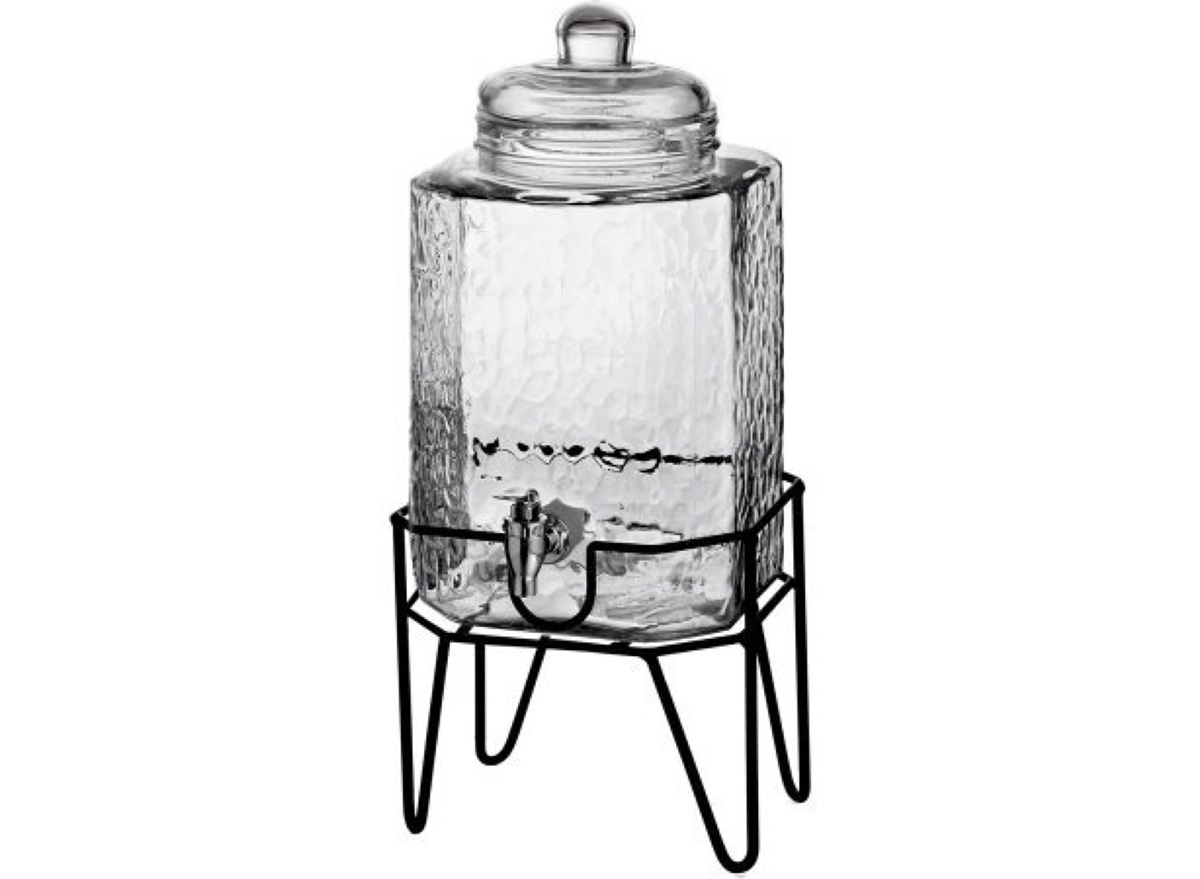 clear glass drink dispenser with black metal legs