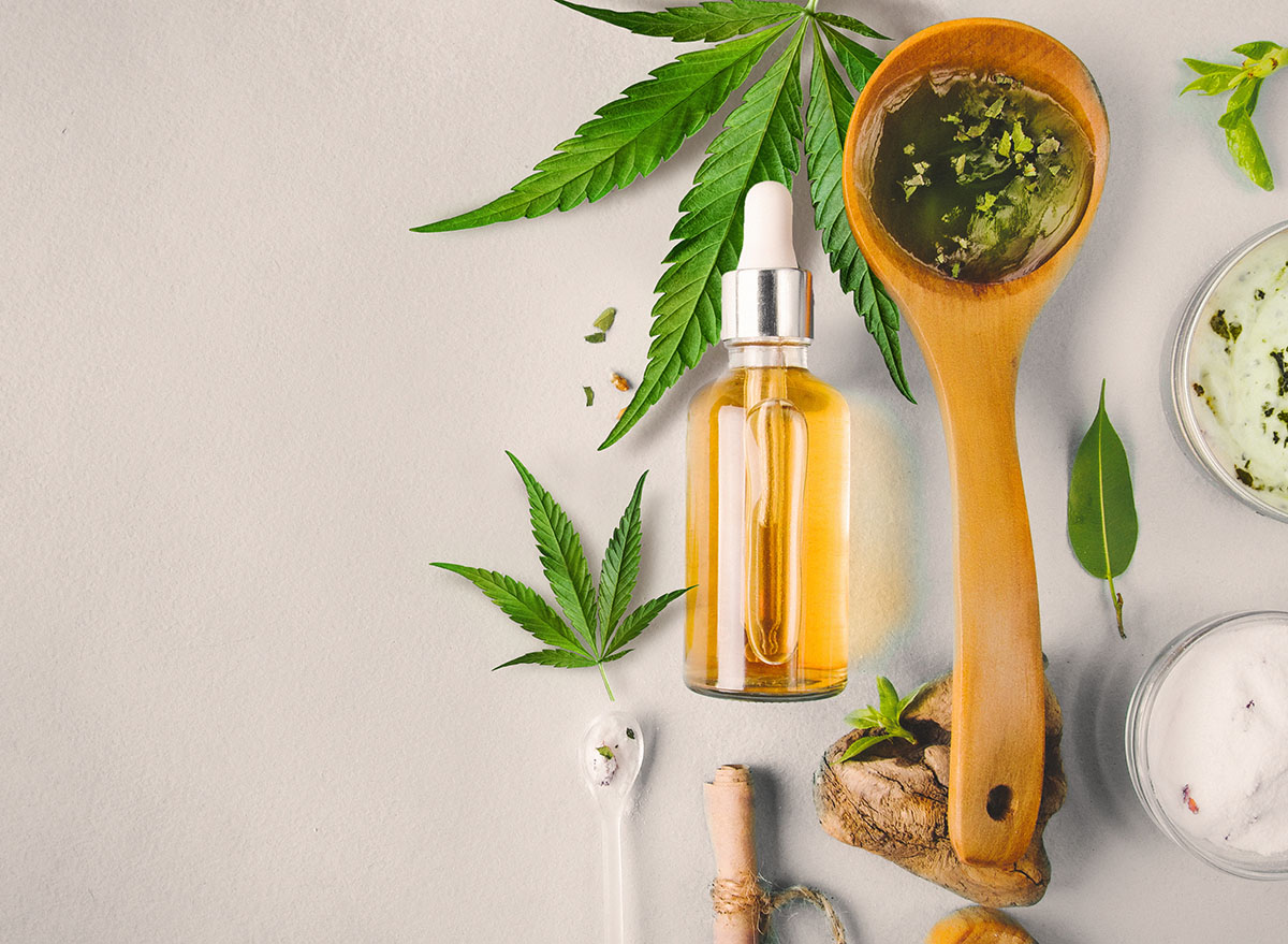 CBD oils in wooden spoon and glass bottle