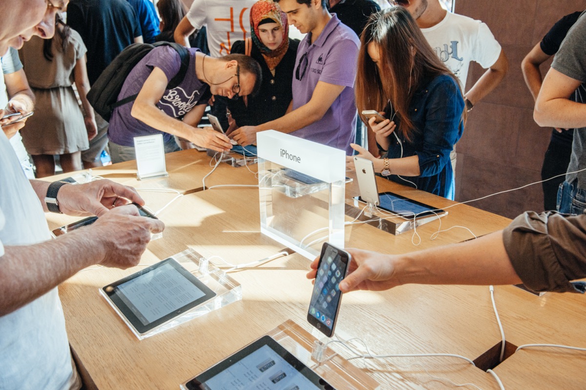 Customers playing with phone gadgets at Apple Store