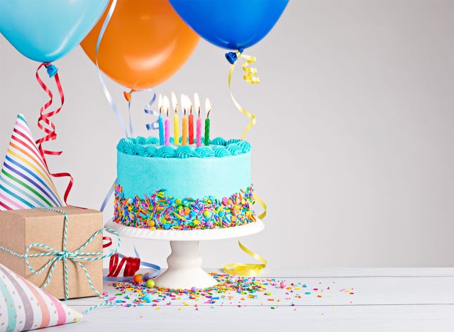 birthday cake with candles balloons gifts