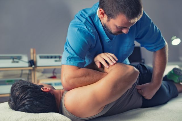 Physiotherapist doing healing treatment on man's back