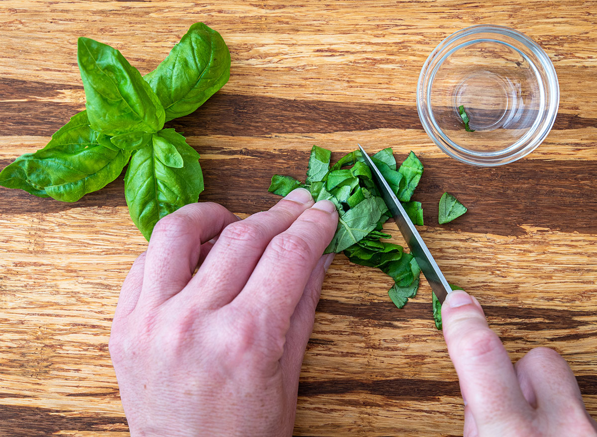 Chopping rolled up basil for easier cutting