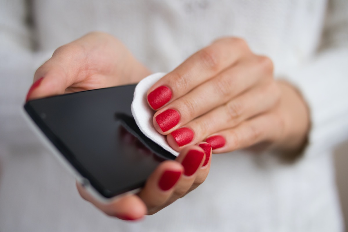 Female hands holding a mobile phone and wipe the screen cloth