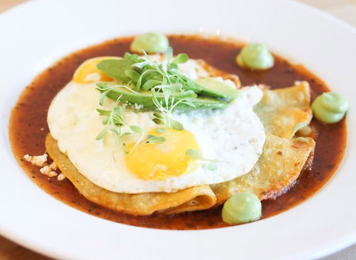 toastada dish with an egg on top in a red sauce from con huevos