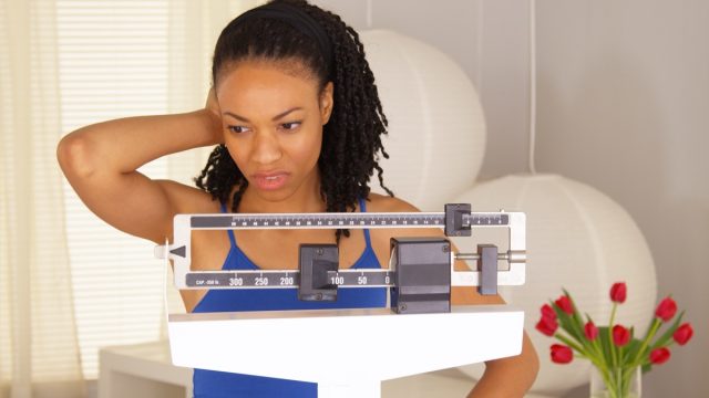 woman disappointed after checking weight