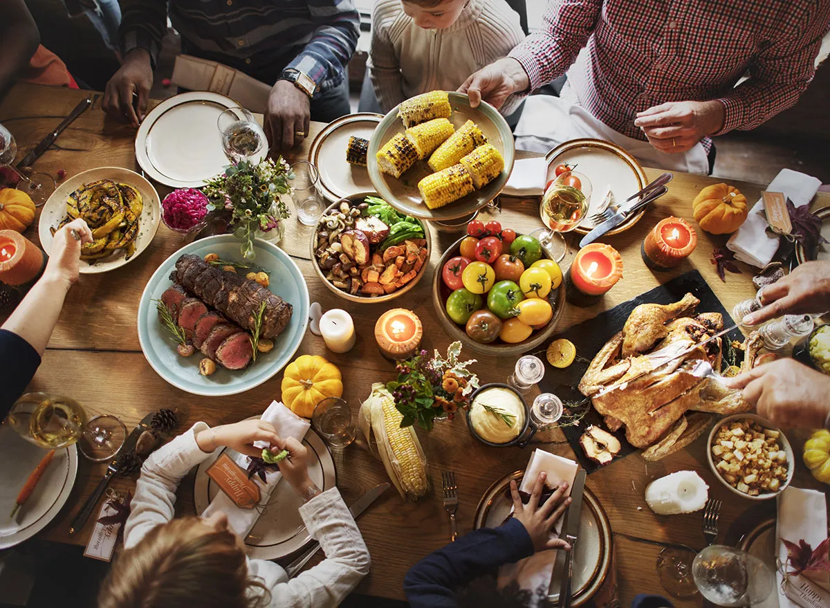 family celebrating thanksgiving at the table eating dinner