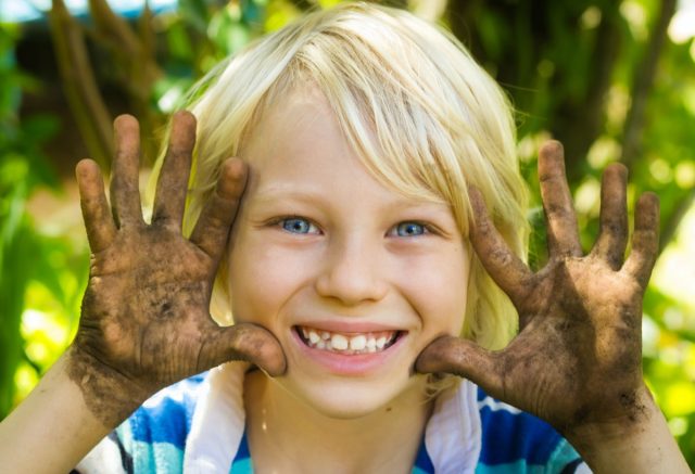 boy playing outside with dirty hands