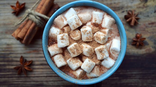 hot chocolate with marshmallows and cinnamon in a blue mug
