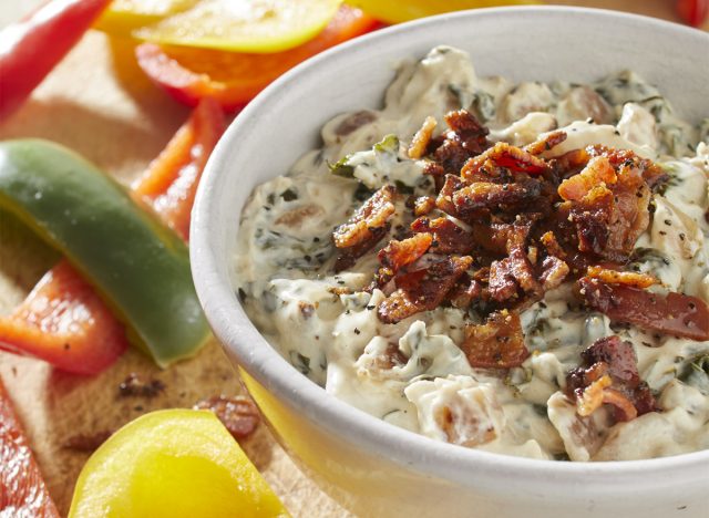 keto bacon spinach dip in a white bowl topped with bacon bits