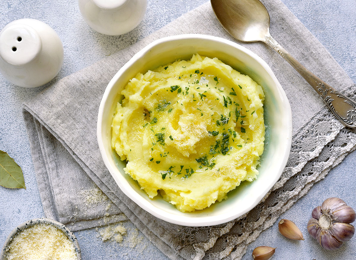 mashed potatoes with olive oil in a white bowl and spoon