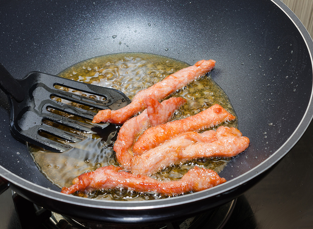 meat strips fried in a black pan