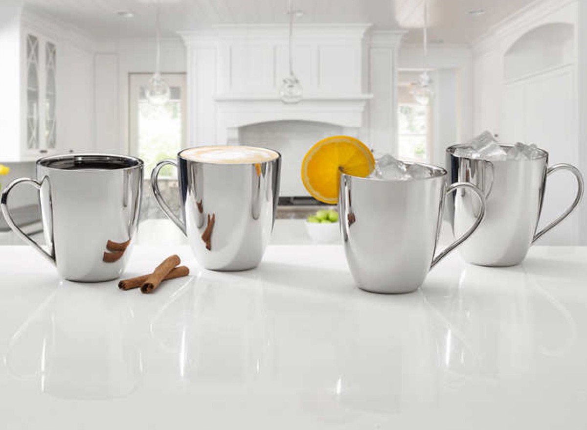 set of steel mugs on white countertop