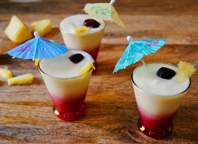 paleo pina colada smoothie in three glasses with little umbrellas
