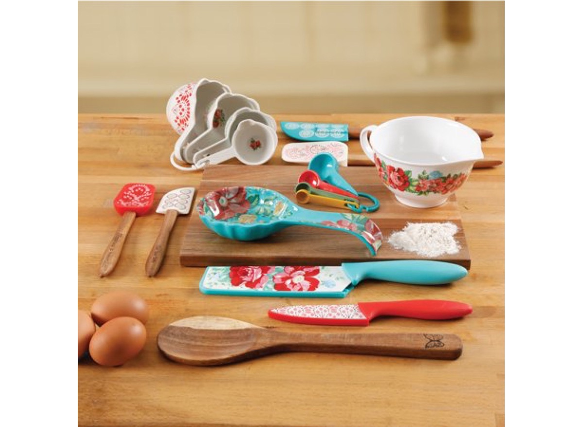 set of colorful kitchen spatulas and measuring cups on wooden counter