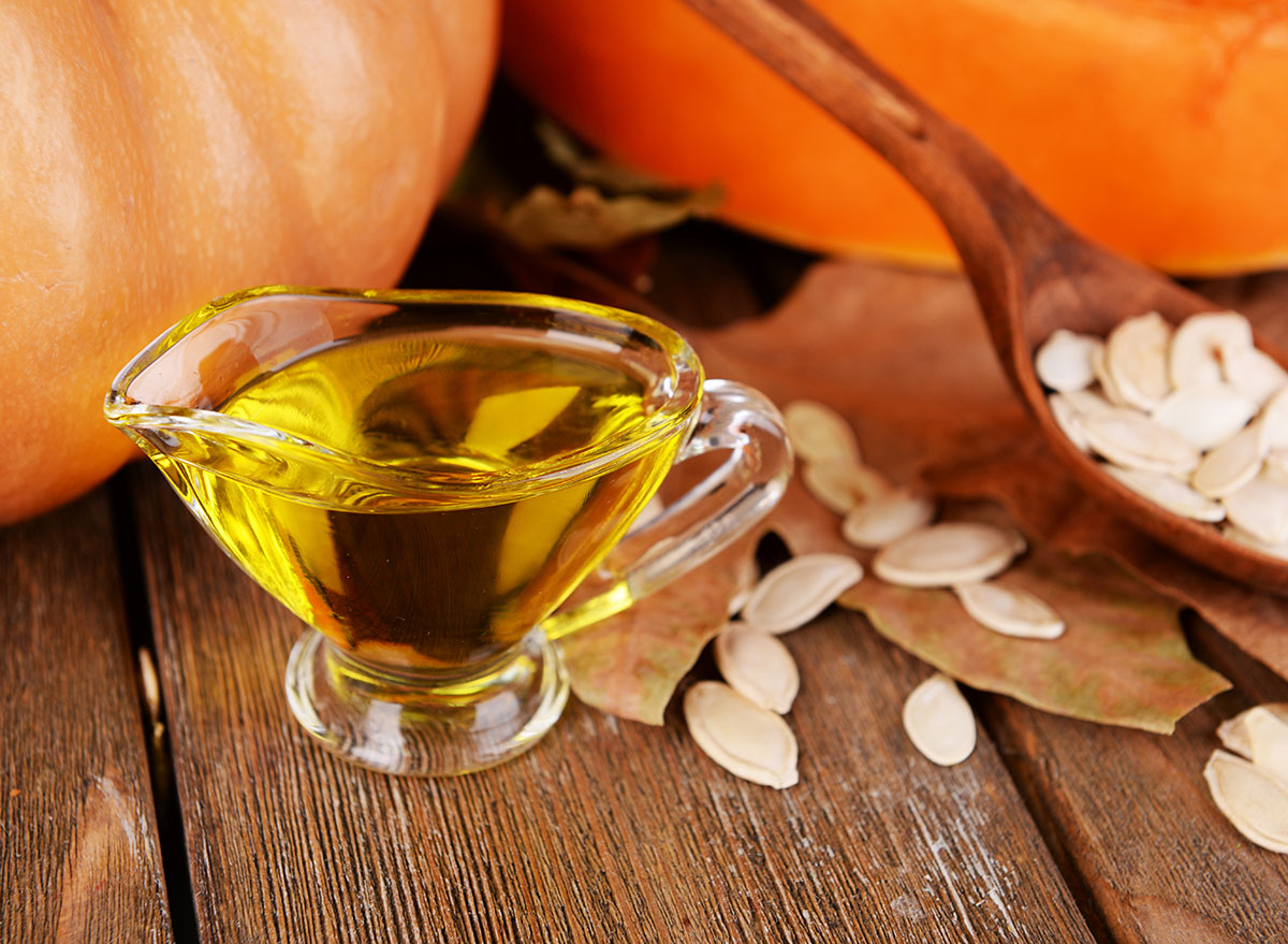 pumpkin seed oil in glass serving container on wooden background