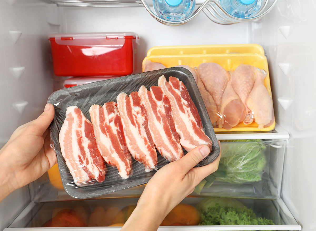 raw bacon being taken out of the refrigerator