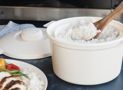 white rice cooker with wooden spoon in it