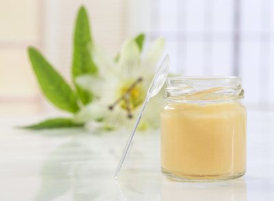 royal jelly in glass jar with spoon