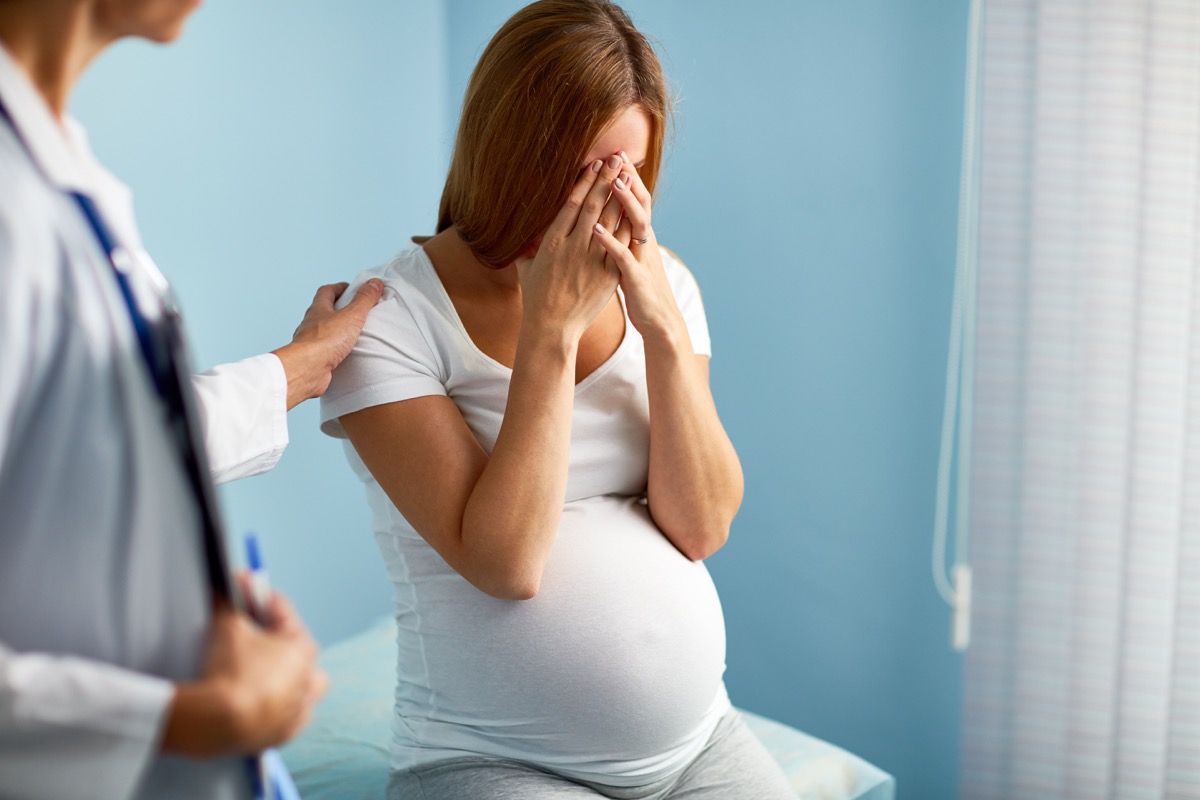 pregnant woman crying at doctor's office