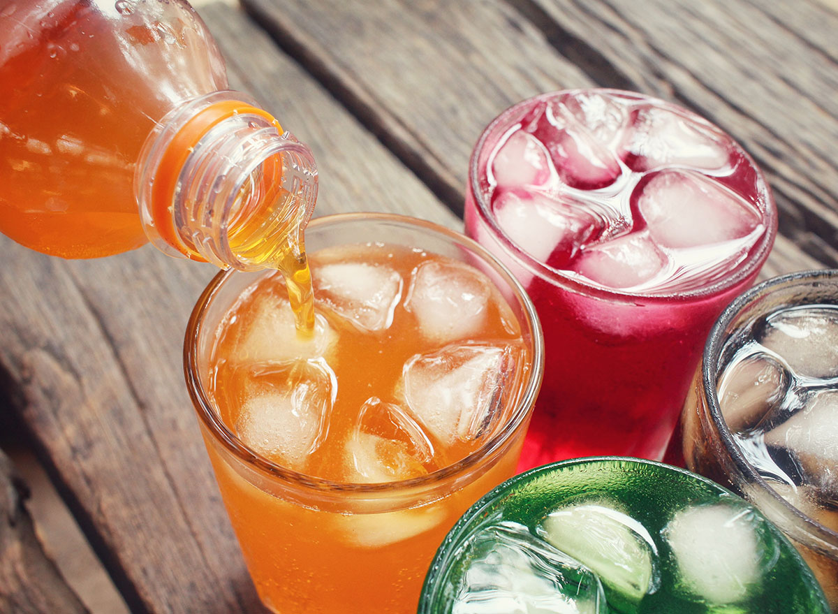 colorful soft drinks being poured into four glasses