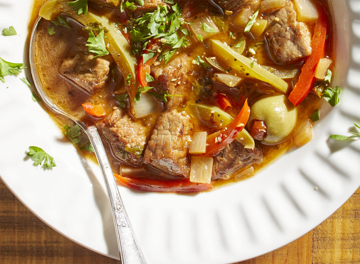 spanish pepper beef stew with olives in a white bowl