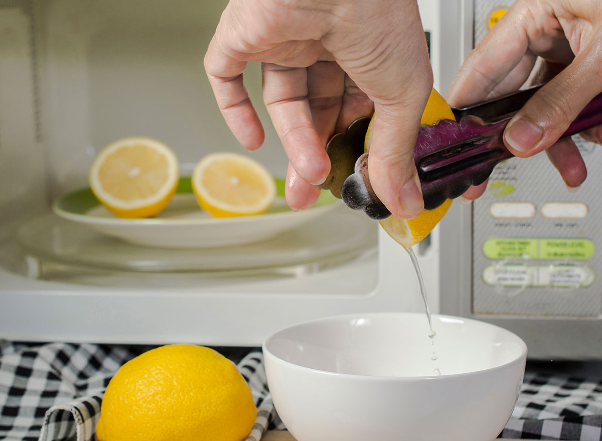 Squeezing lemon with tongs into a bowl