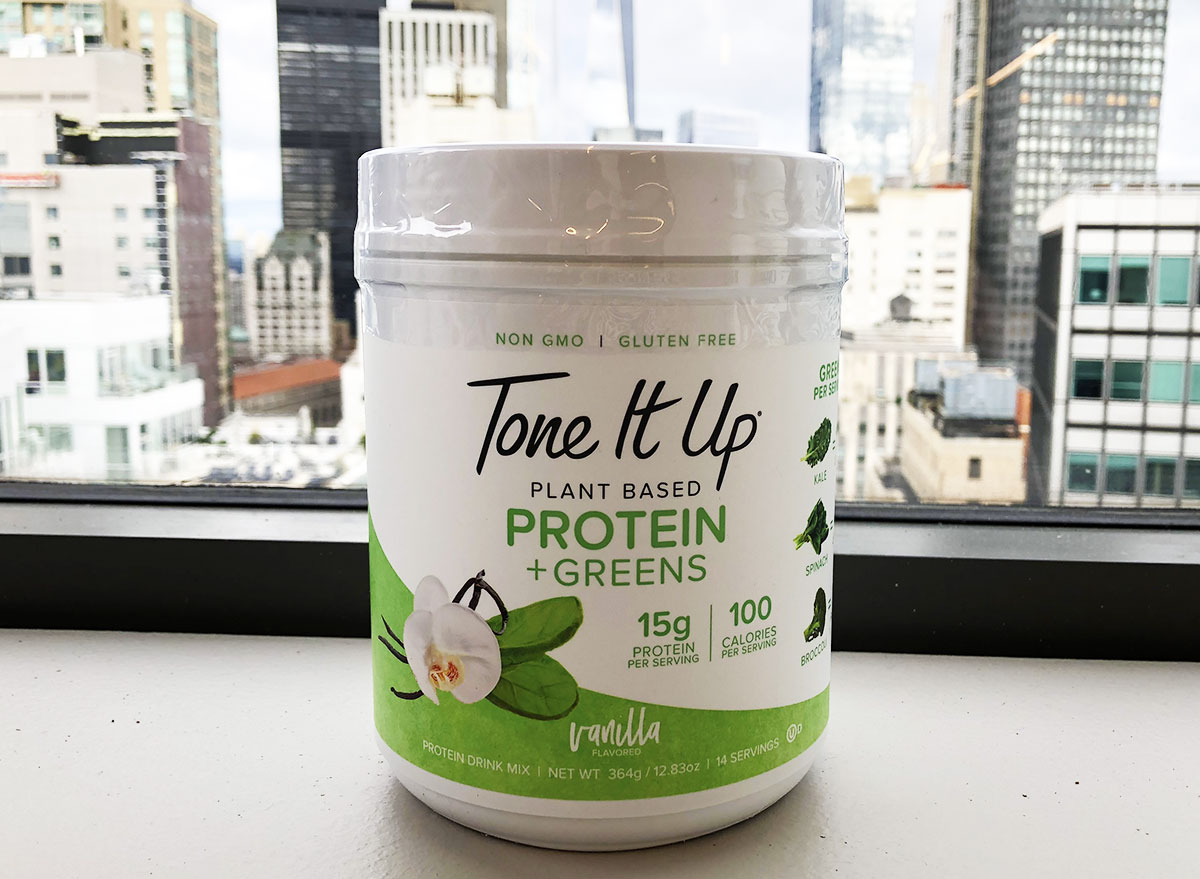 container of vanilla flavored tone it up brand plant based protein greens powder