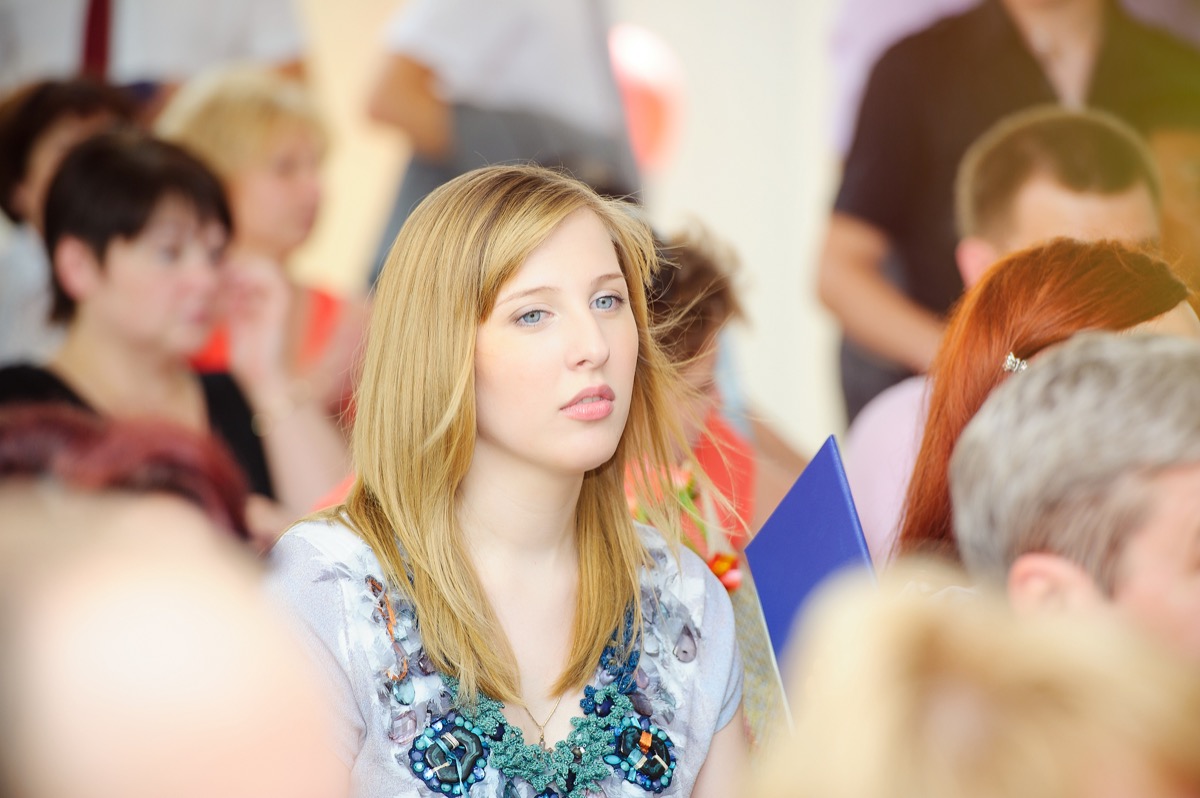 young pensive woman in a crowd of people