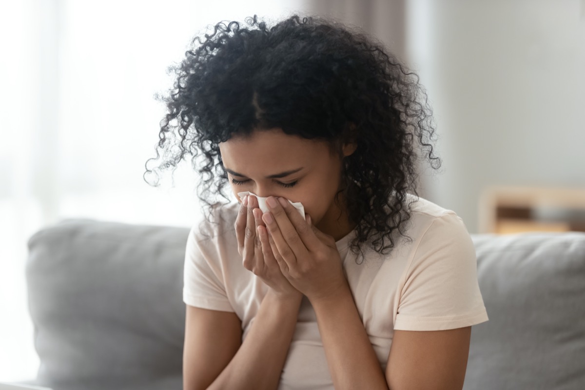 woman blowing running nose got flu caught cold sneezing in tissue
