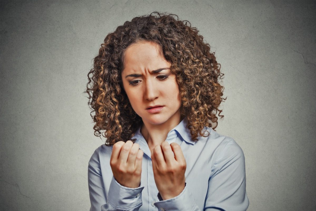 worried woman looking at hands fingers