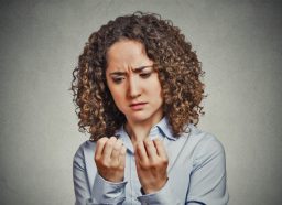worried woman looking at hands fingers