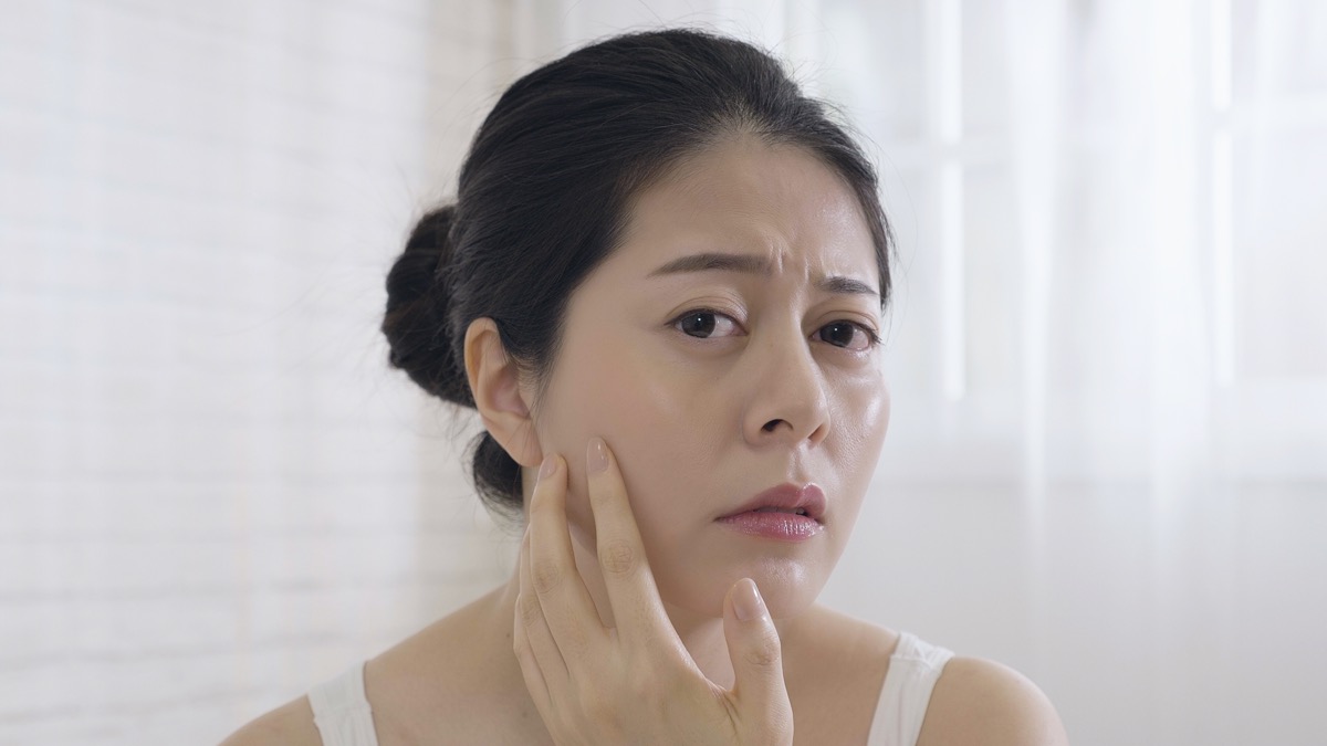 woman squeezing pimple