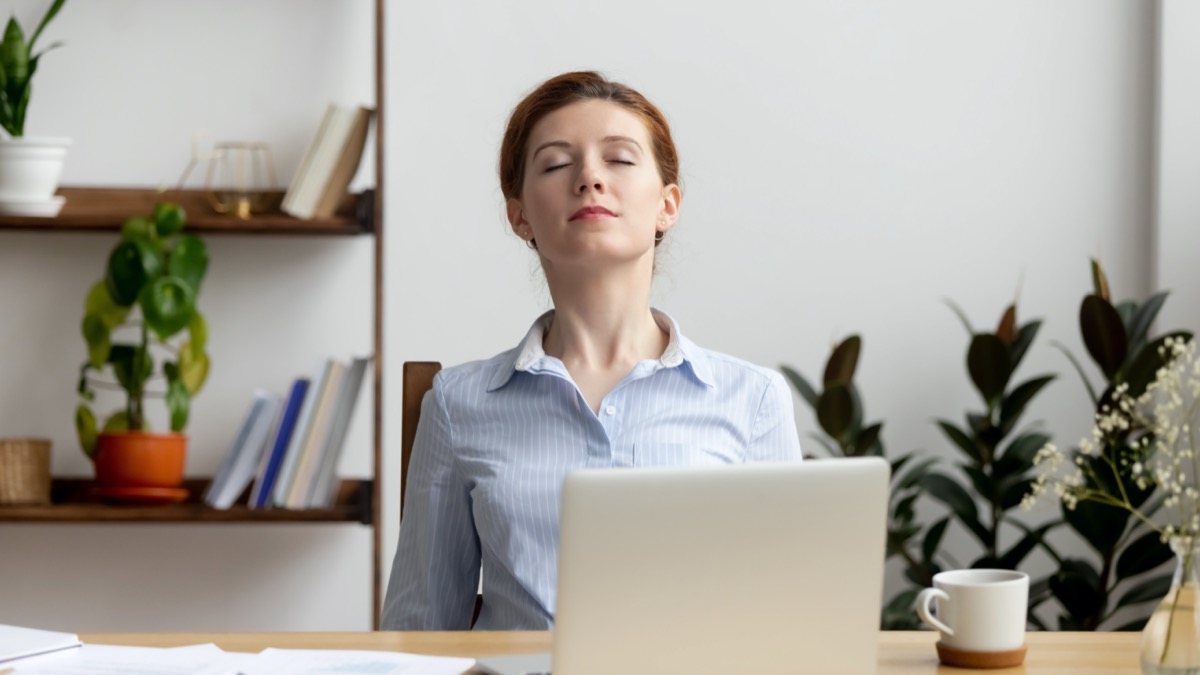 Businesswoman breathing, stretching shoulders after hard work feeling discomfort at office desk work