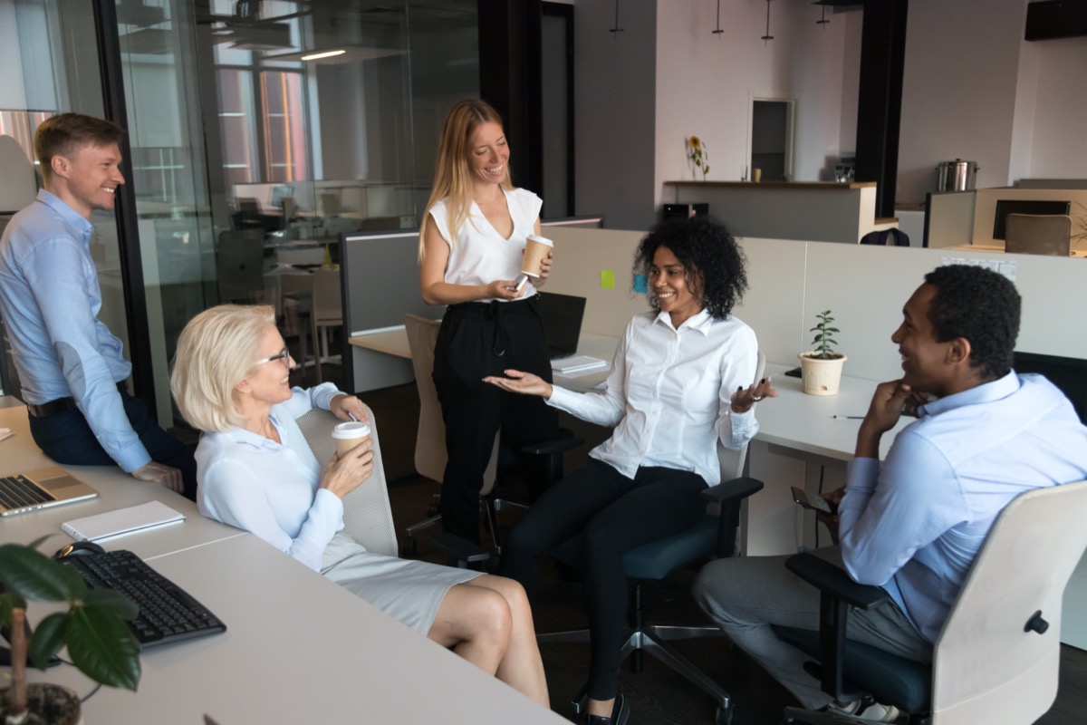 woman telling funny story to colleagues while resting in co-working office