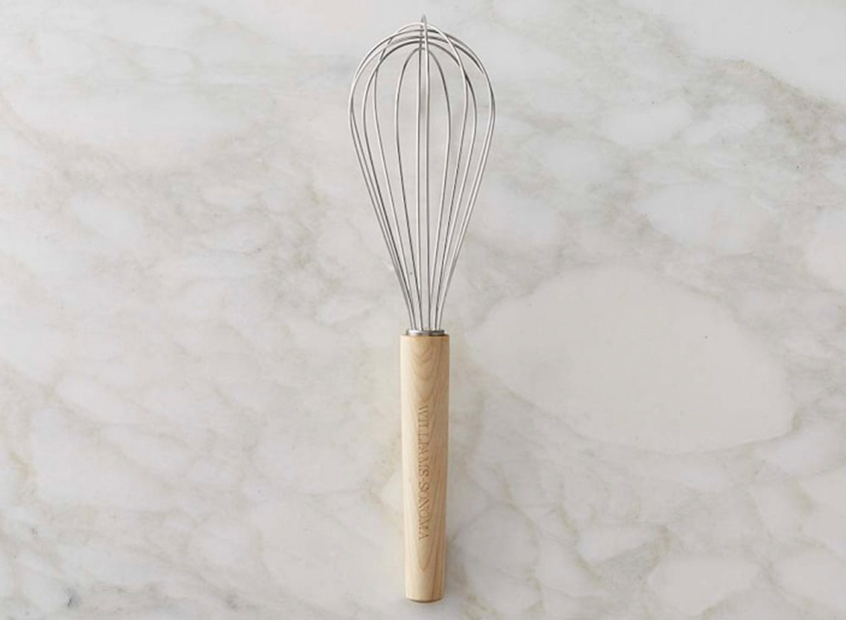 wooden handle whisk from william sonoma with marble background