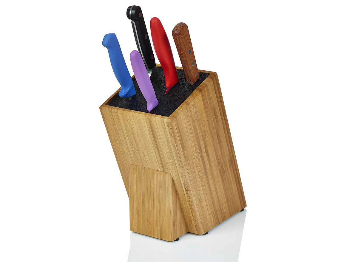 wooden knife block with colorful knives in it on white background