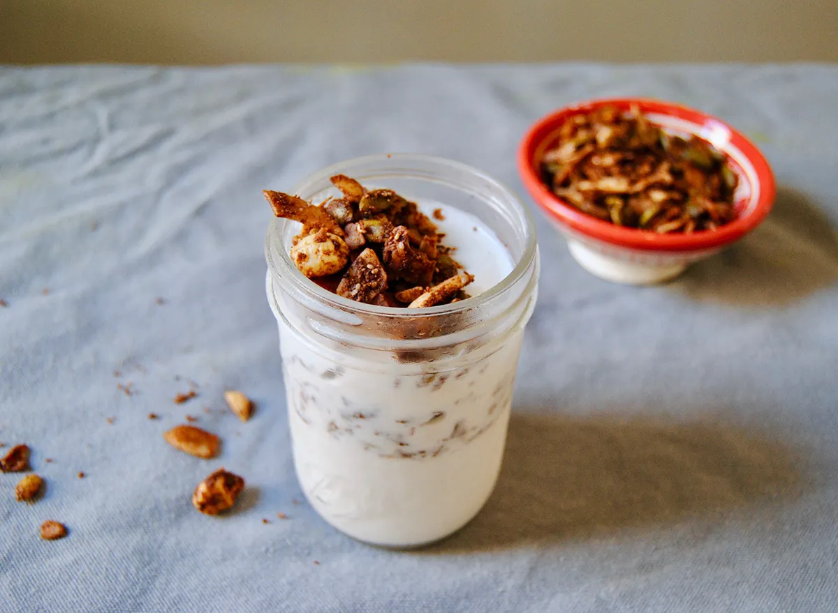 paleo breakfast yogurt and granola smoothie in a mason jar with granola in the background