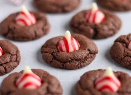 Chocolate cookies with a peppermint kiss on parchment paper