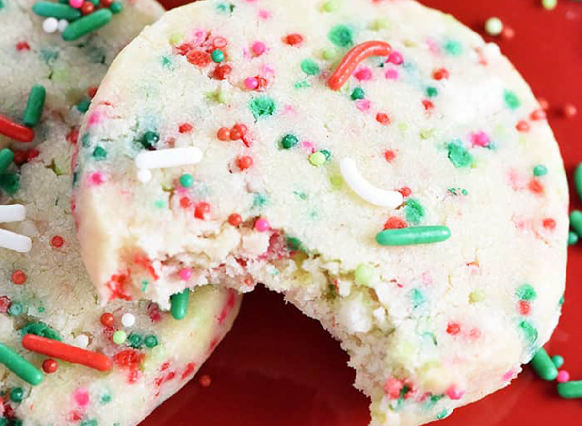 Shortbread cookies with holiday sprinkles on a red table