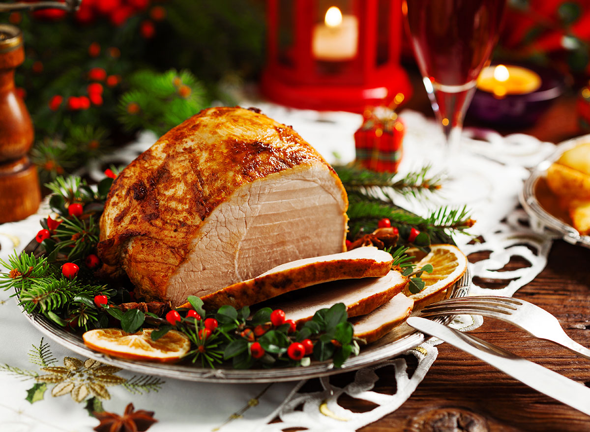baked holiday ham with festive garnish on table