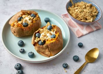 breakfast sweet potato on blue plate with blueberries and yogurt