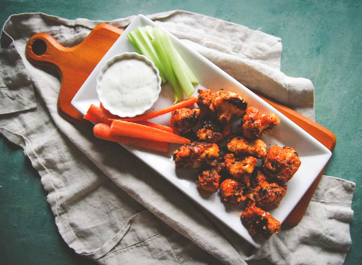 buffalo cauliflower bites on serving tray with celery and carrots