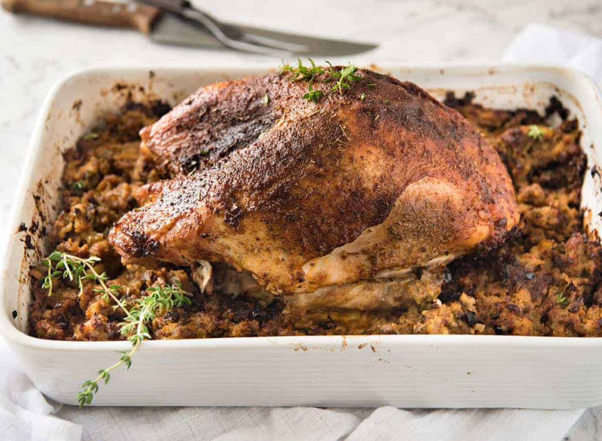 cajun roasted whole turkey in baking pan with stuffing
