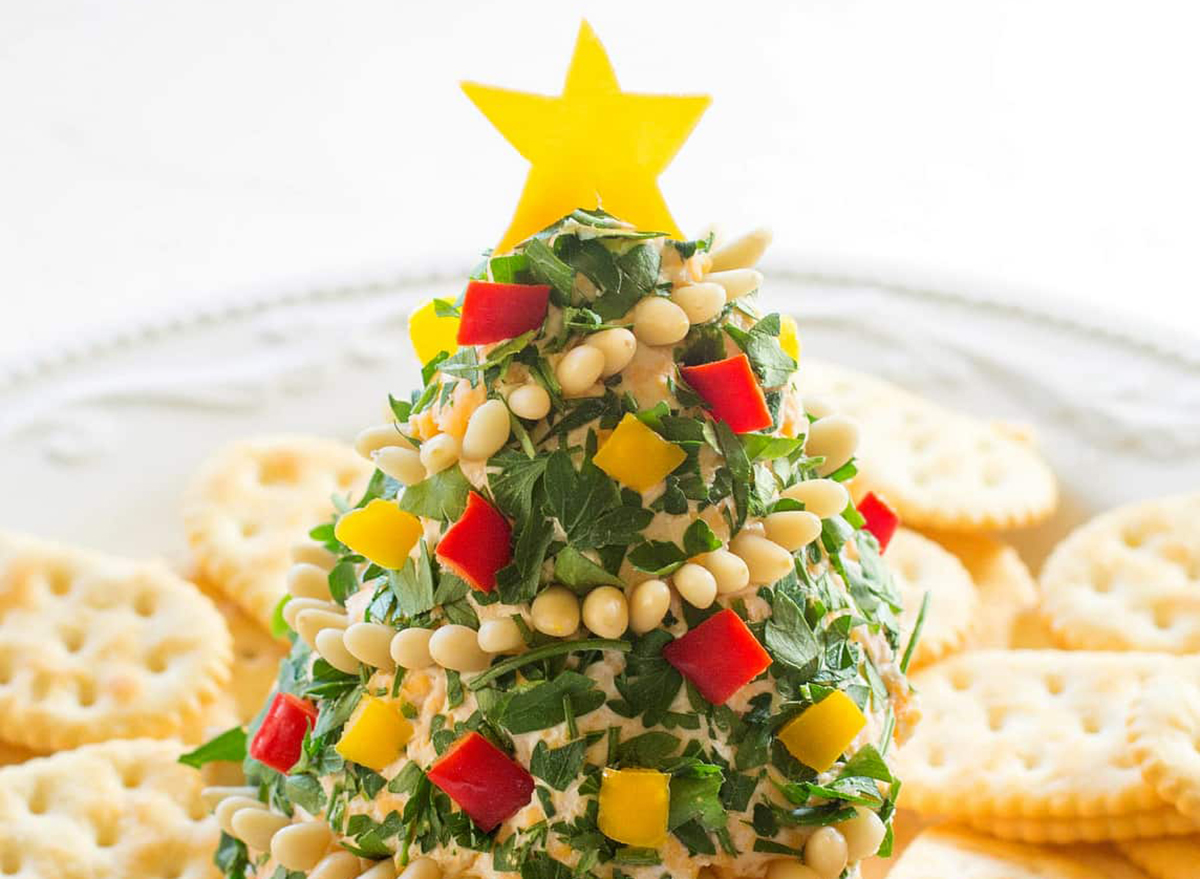 cheese shaped like christmas tree with chopped peppers and crackers