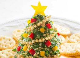 cheese shaped like christmas tree with chopped peppers and crackers