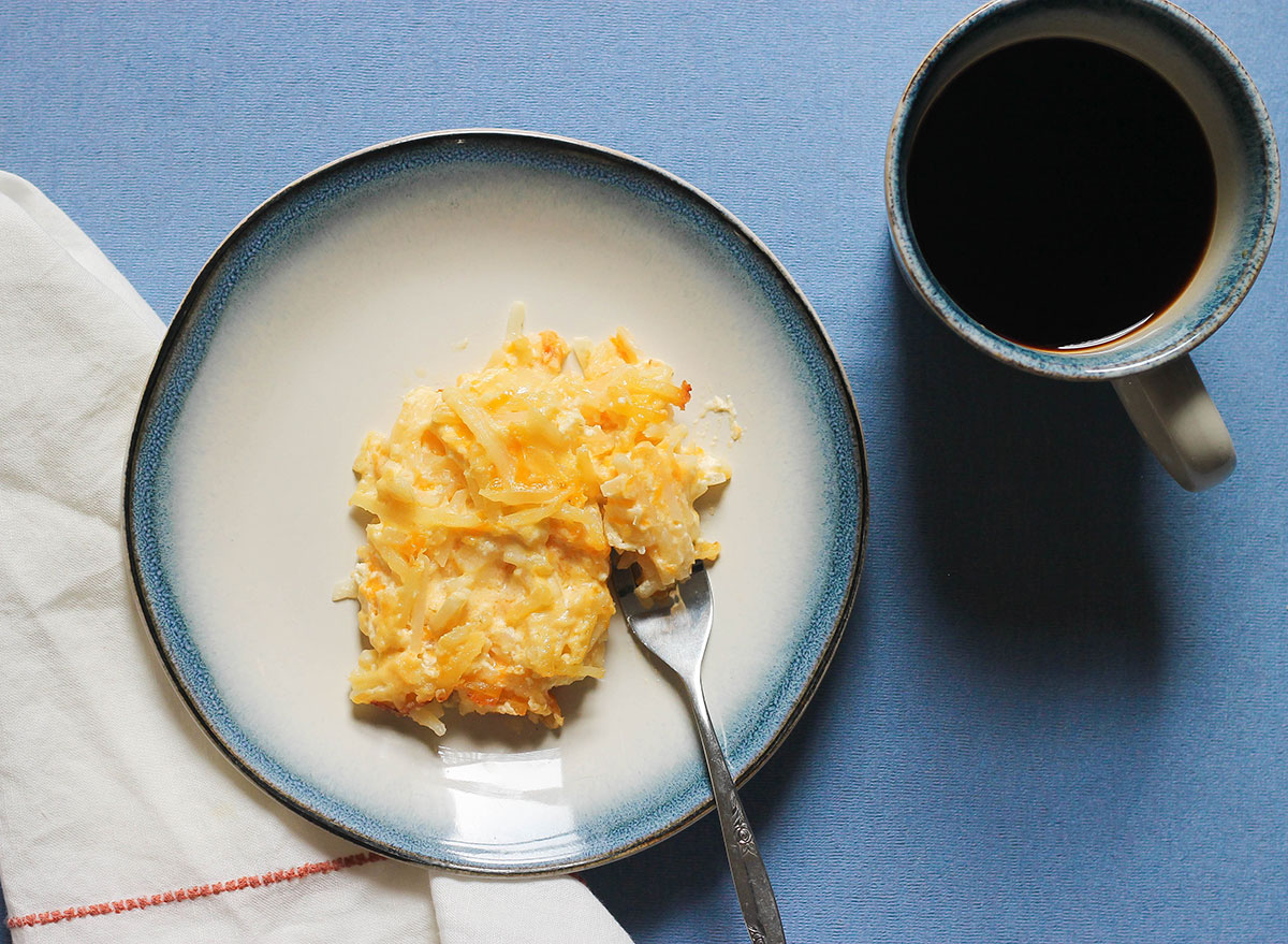 Slice of hashbrown casserole with a cup of coffee
